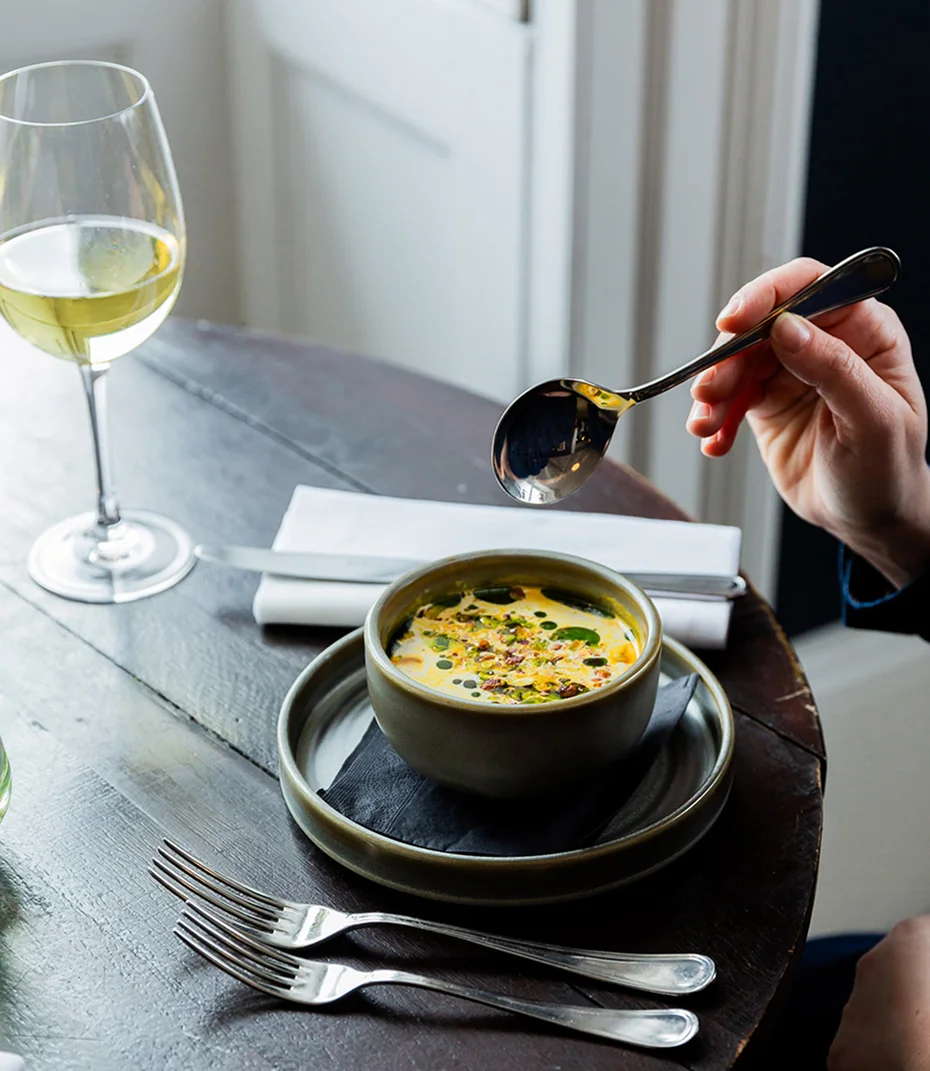 A dish served in the hotel restaurant beside a glass of wine